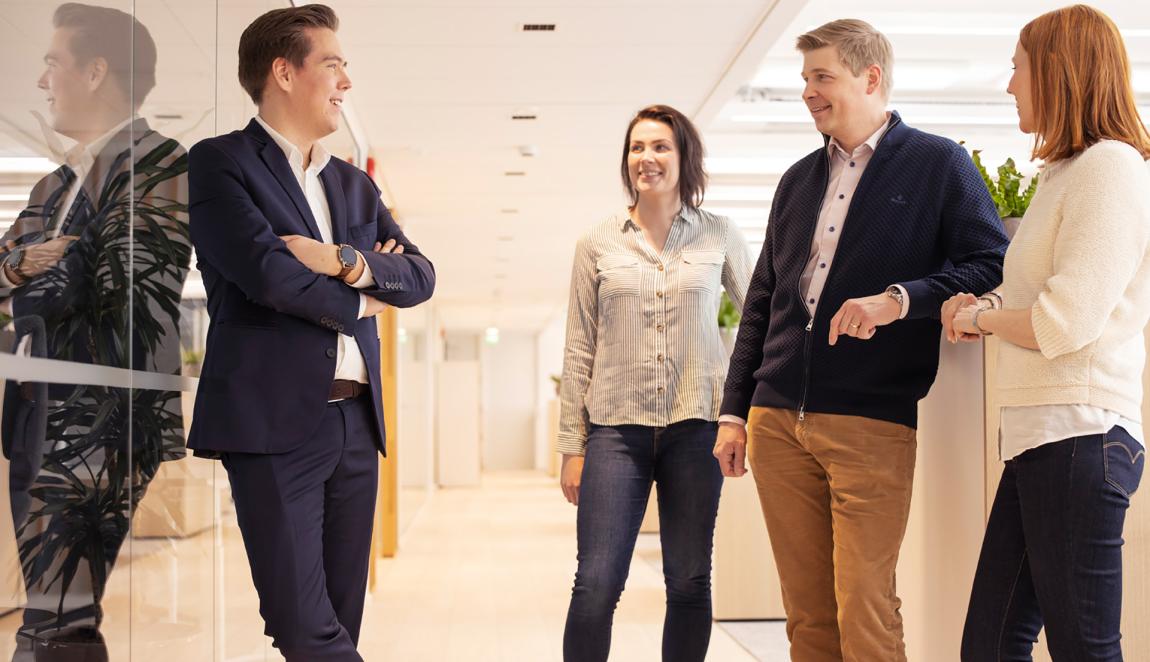 työntekijöitä seisoslee avokonttorissa